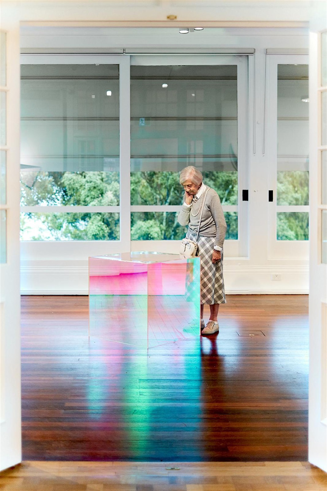 Elderly woman looking at an artwork in the gallery
