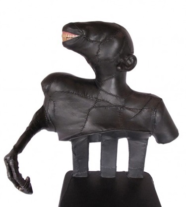 Aly Aitken, Trophy #6 (IKEA Chair: Juvenile), black sheep leather, abandoned IKEA chair, deer foreleg and foot, used dentures, armature of ply, aluminium strip and wadding thread, 78 x 46 x 31 cm.
