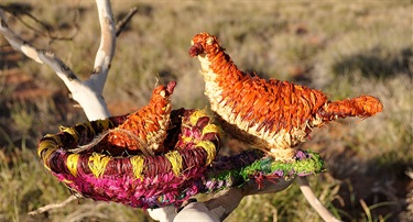 Margaret Poulson, Tjulpuku Ngunytju Tjitji Kanyini (Mother bird caring for children), raffia, emu feathers, 19 x 23 x 39 cm. Courtesy of Tjanpi Desert Weavers.